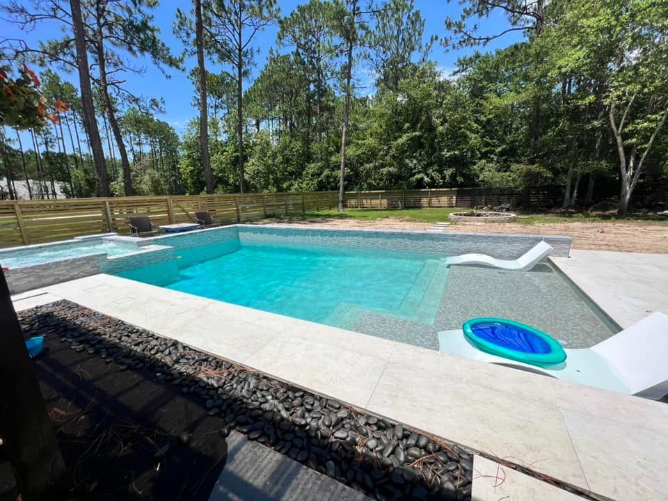 Clean backyard pool with a lounger on the tanning ledge
