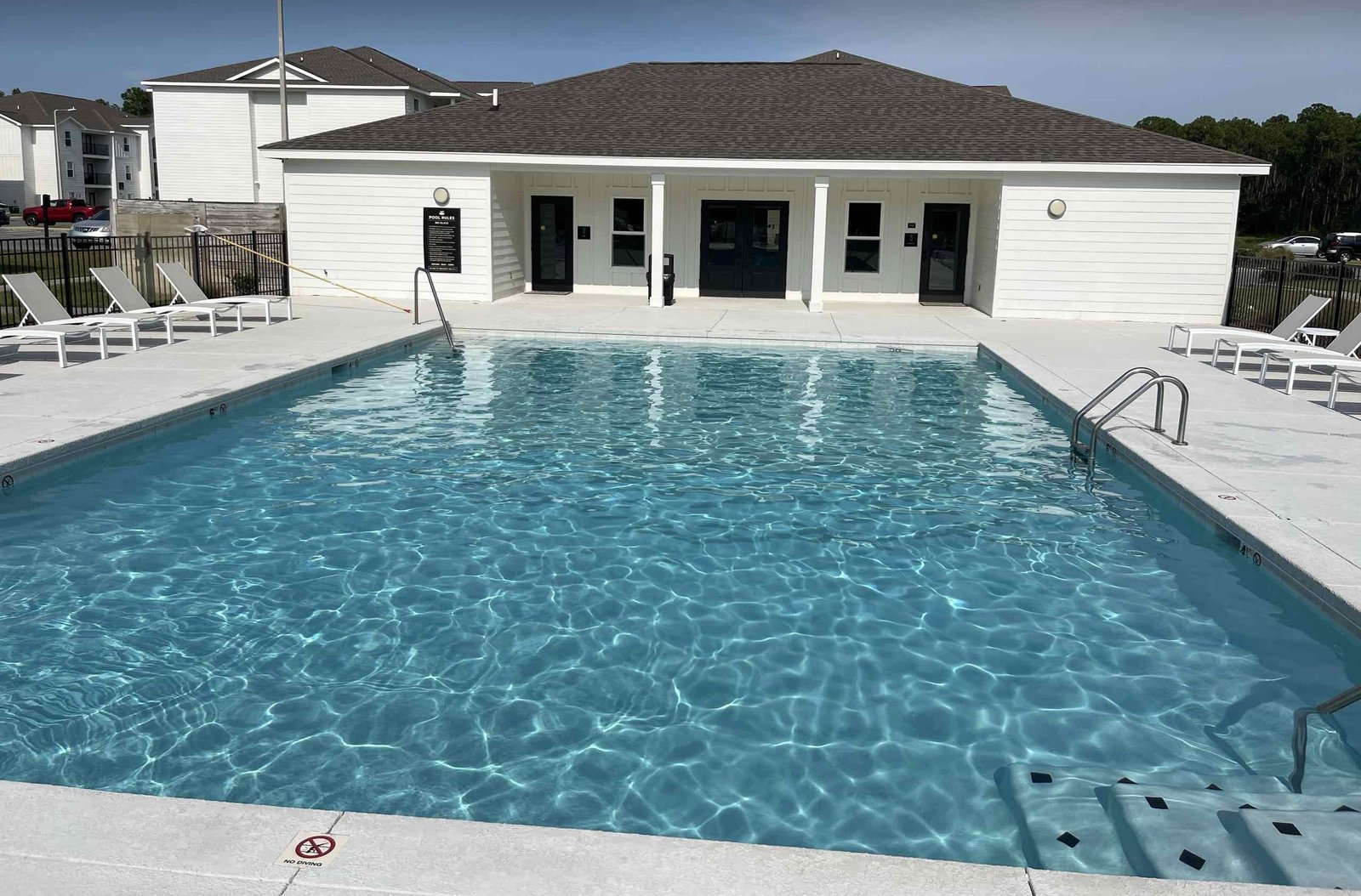 Sparkling commercial pool in Ocean Springs with the pool house behind it after a clean