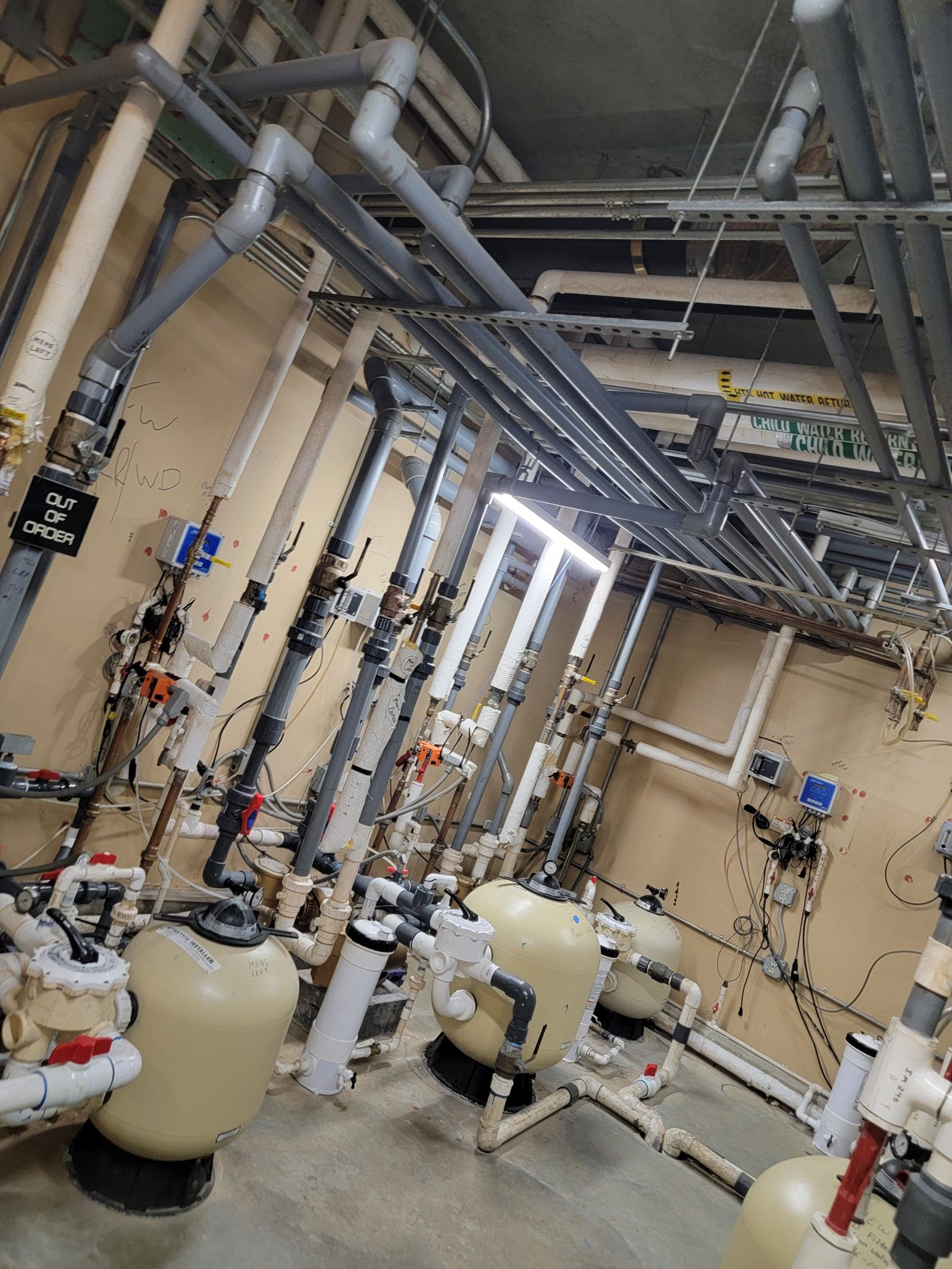 Commercial pool equipment room with sand filters and plumbing manifolds