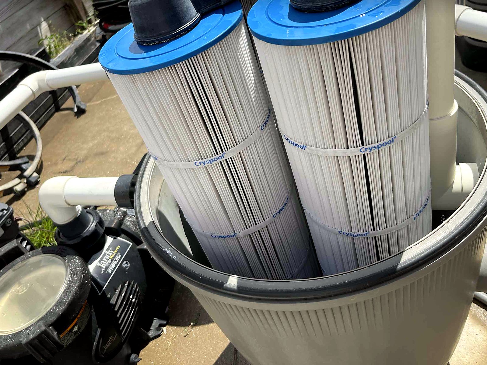 New cartridges going into a pool filter next to the pump