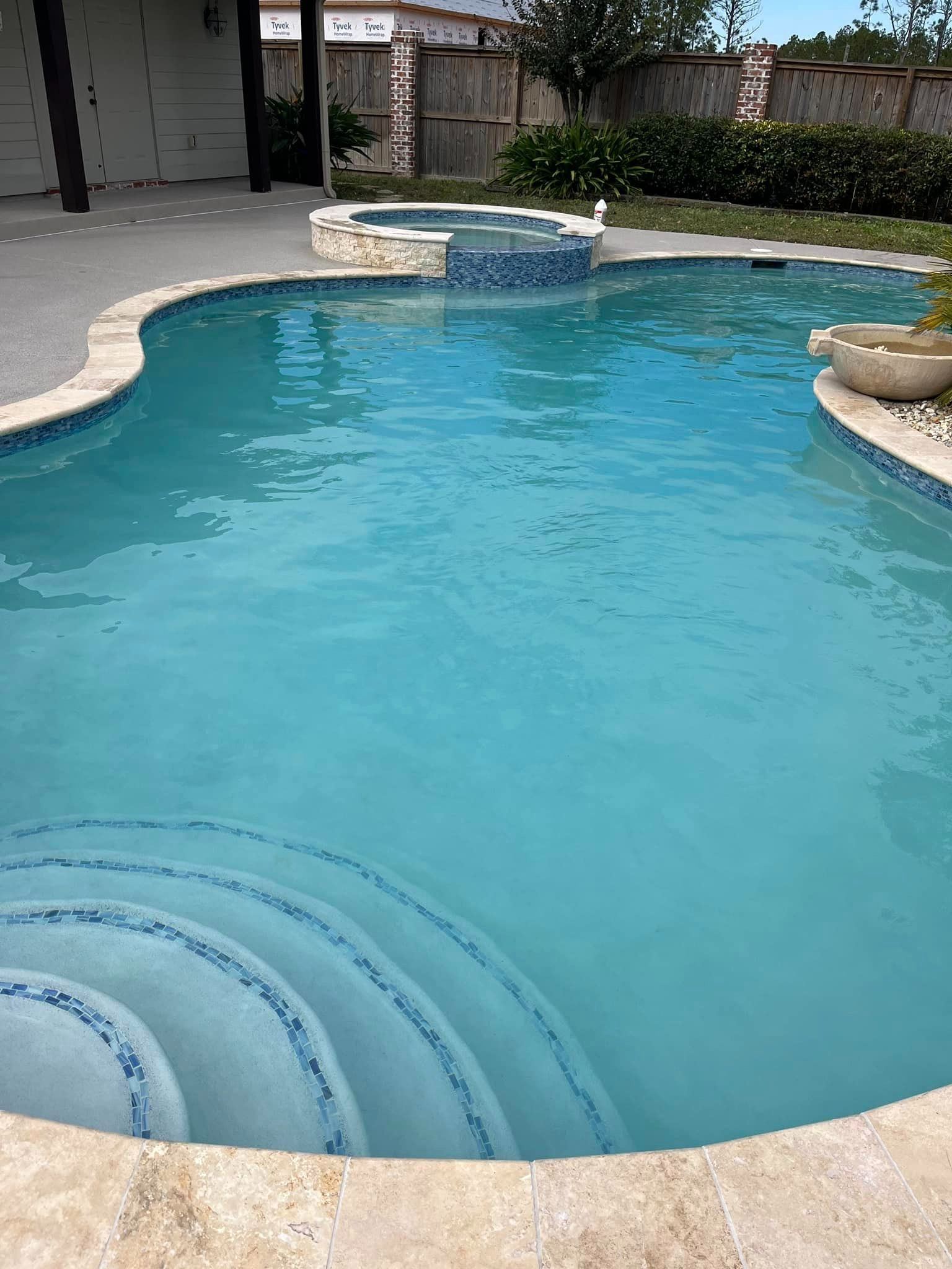 Freeform pool with attached spa and curved steps