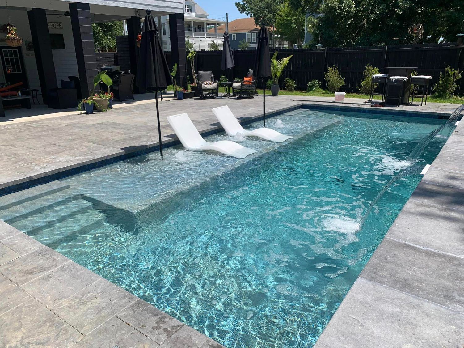 Pool with a tanning ledge, two loungers and a sheer descent