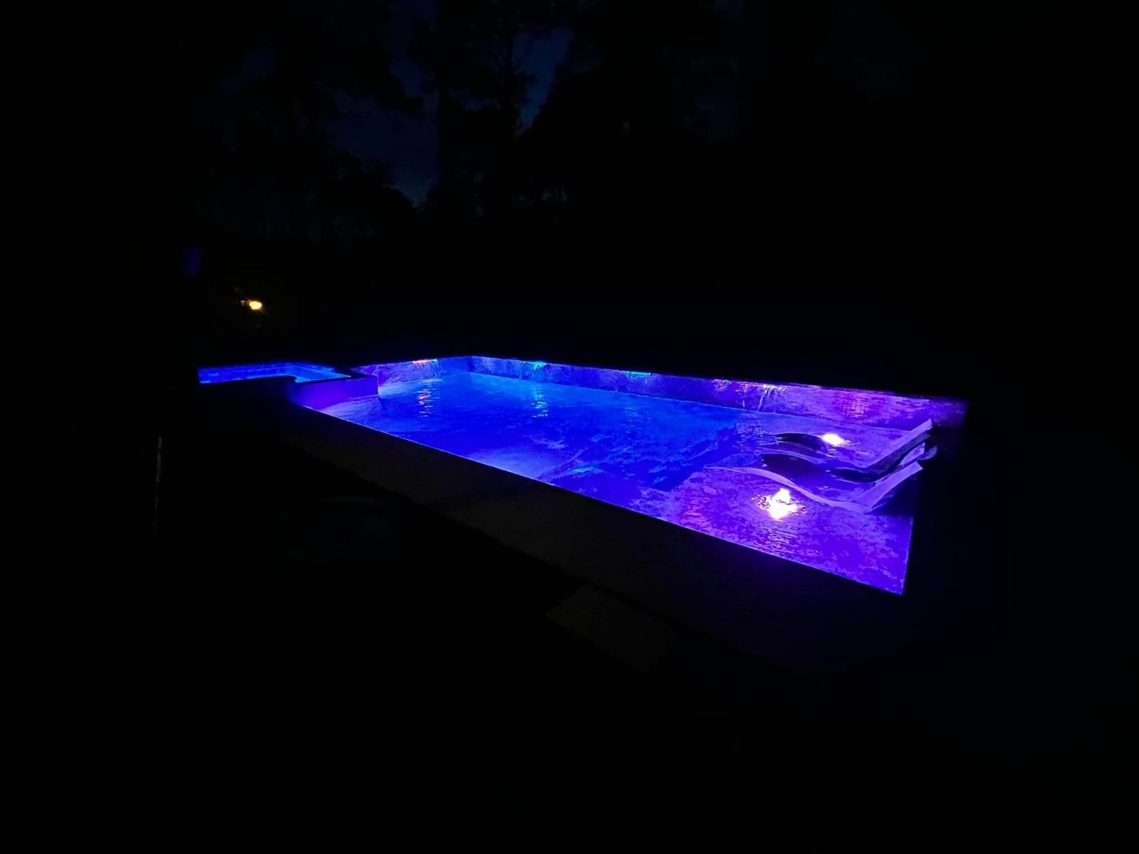 Pool glowing purple under LED lights at night